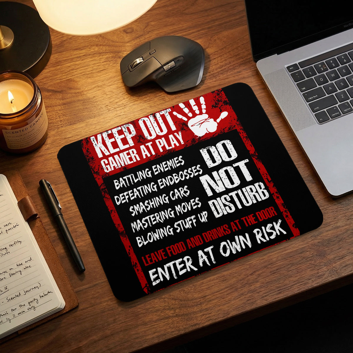 A black and red gamer mousepad features the text Keep Out Gamer At Play and Do Not Disturb on a wooden desk.