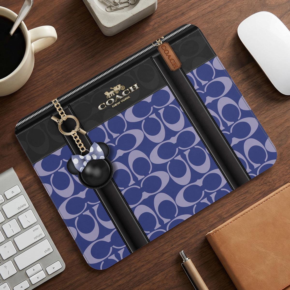 Coach tablet case with purple signature C pattern, black trim, and Mickey Mouse charm.
