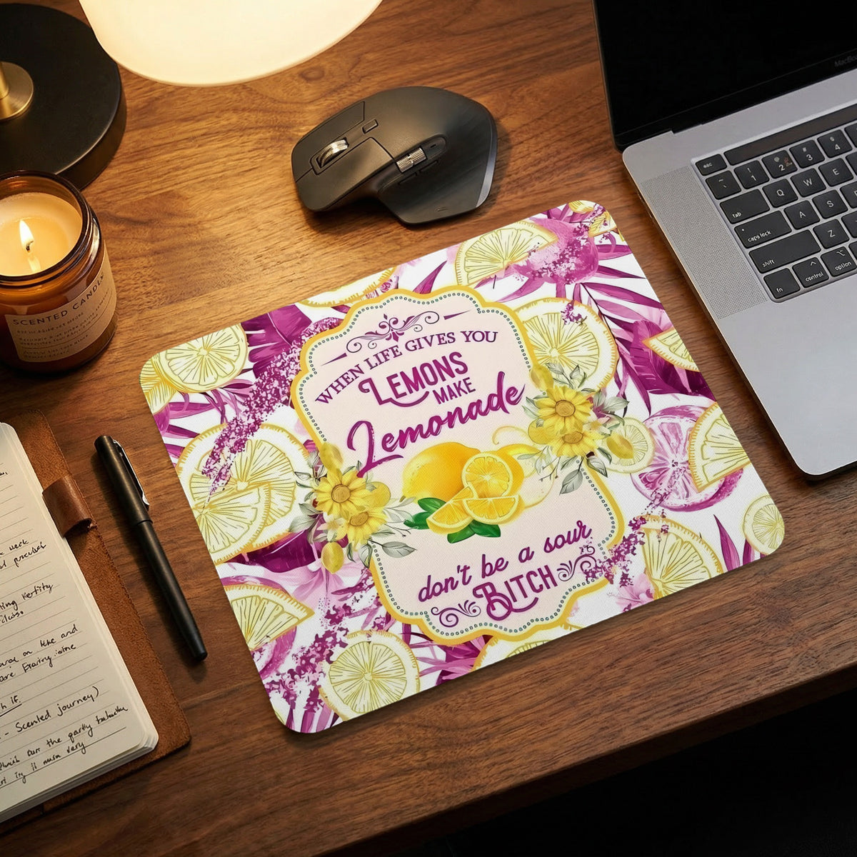 Rectangular mouse pad featuring a pink and yellow lemon pattern and humorous typography on a wooden desk.