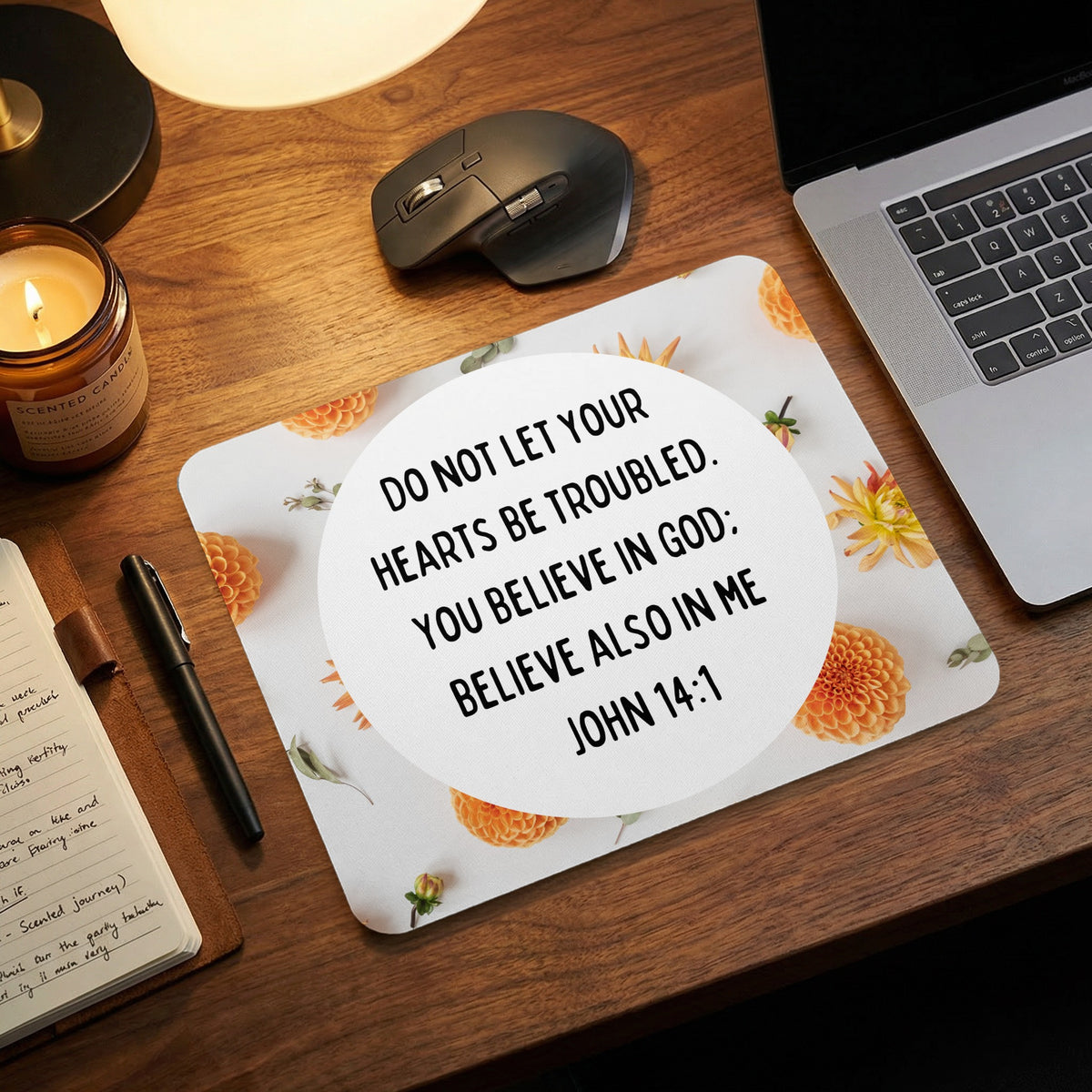 A rectangular mousepad featuring a floral pattern and the Bible verse John 14:1 on a wooden desk.