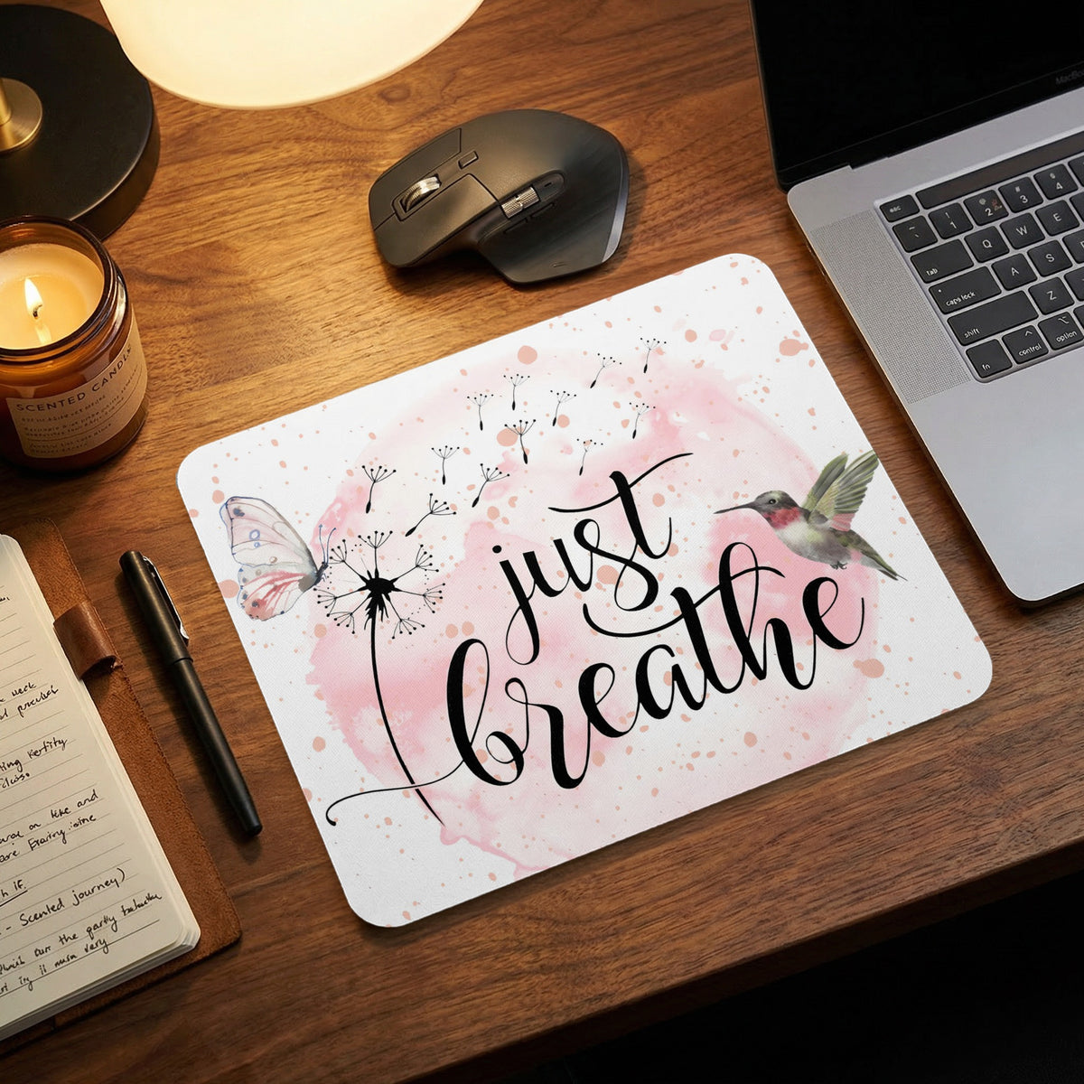 A rectangular mousepad featuring the text just breathe surrounded by a butterfly, hummingbird, and dandelion.
