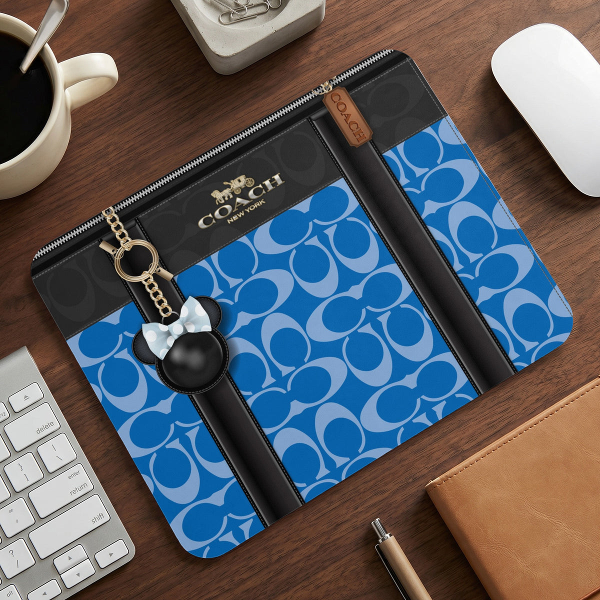Coach monogram print pouch with Mickey Mouse charm and gold keychain.