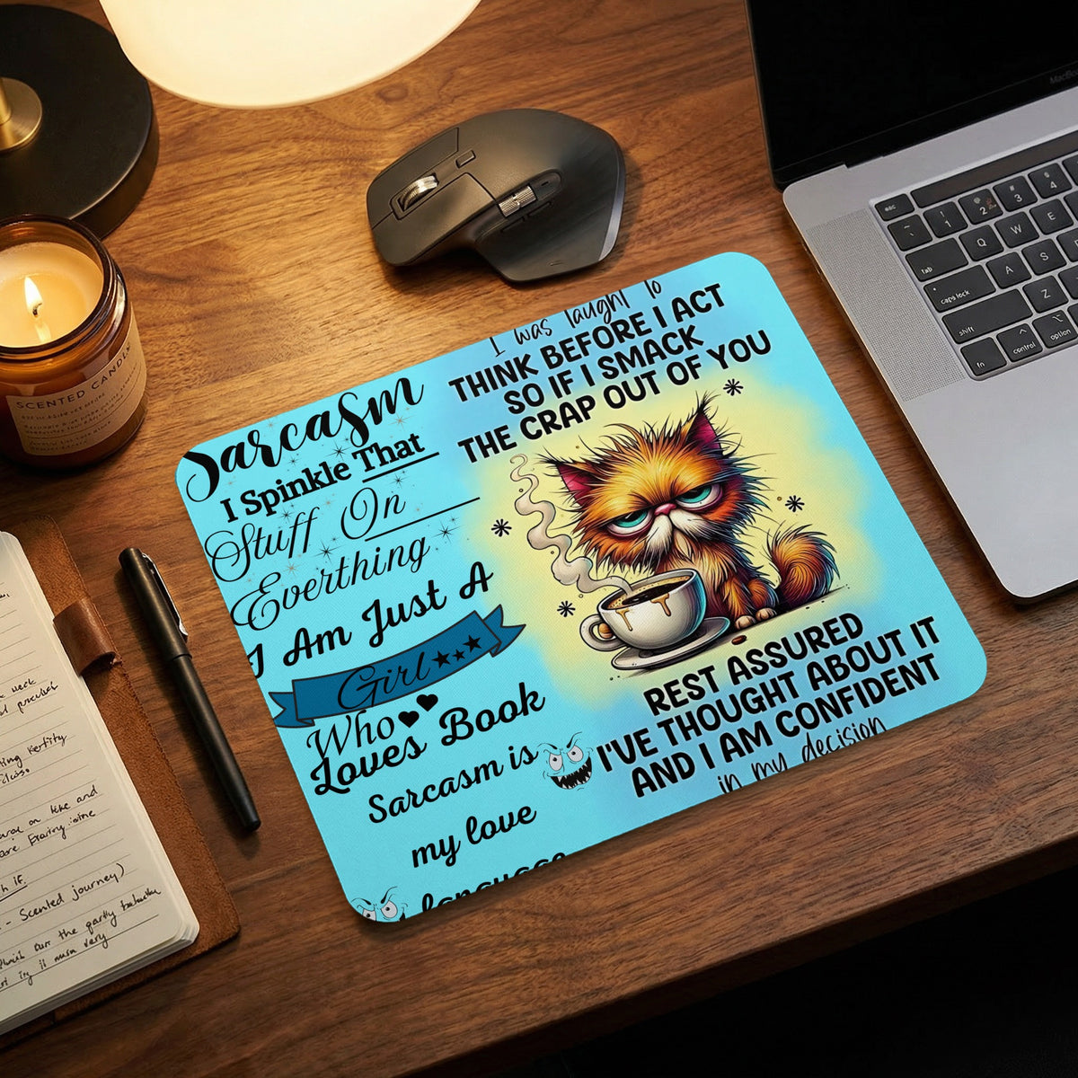Light blue mousepad with sarcastic text and an angry cat illustration on a wooden desk.