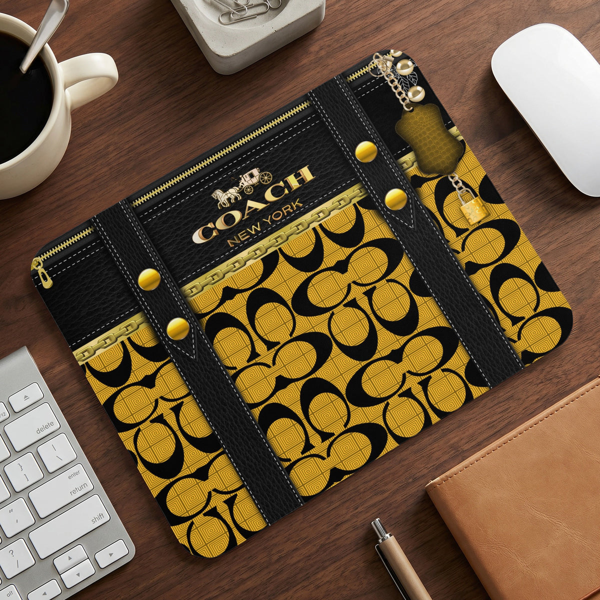 Coach New York mousepad with gold and black monogram pattern and zipper detail.