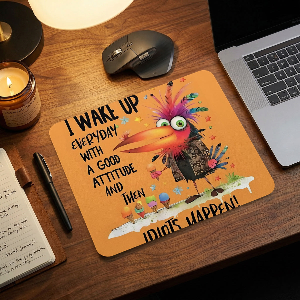 Orange mouse pad with a quirky bird illustration, humorous text, and office desk accessories.
