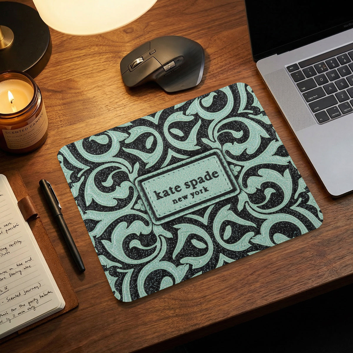 Kate Spade New York mousepad with black and mint green ornate pattern.