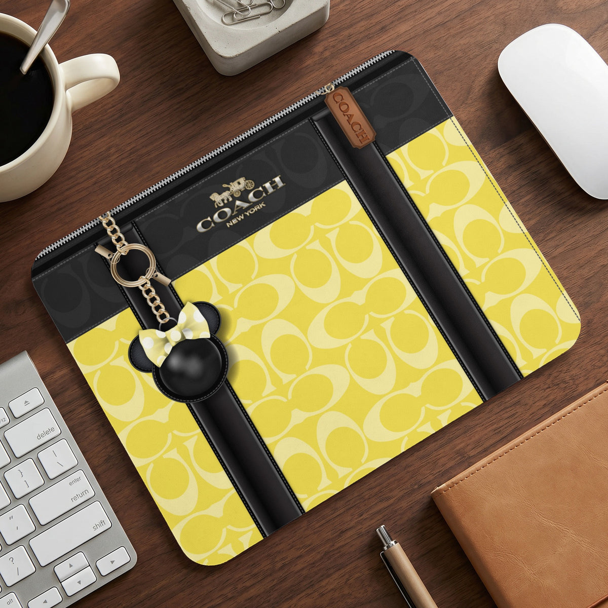 Coach yellow monogram clutch with black accents and a Minnie Mouse charm.