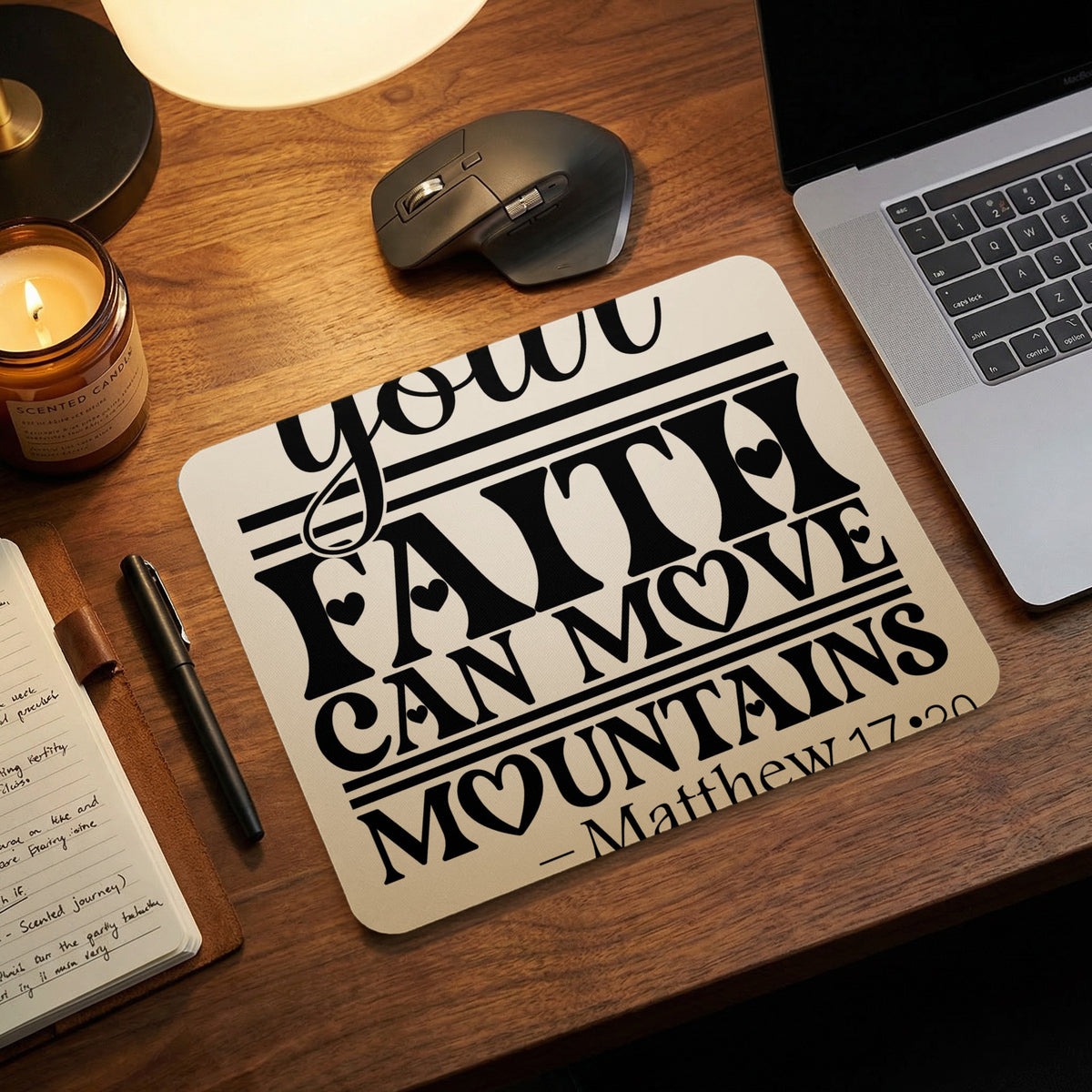 Off-white rectangular mousepad with black text reading Your Faith Can Move Mountains Matthew 17:20 on a wooden desk.