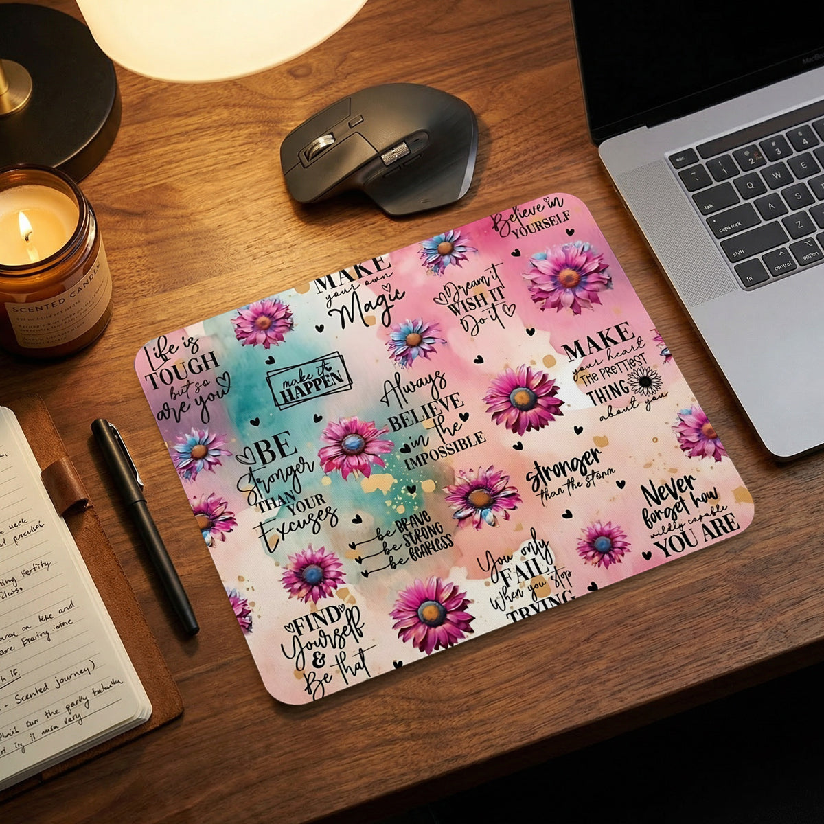Pink and turquoise mousepad featuring watercolor flowers and motivational typography on a wooden desk.