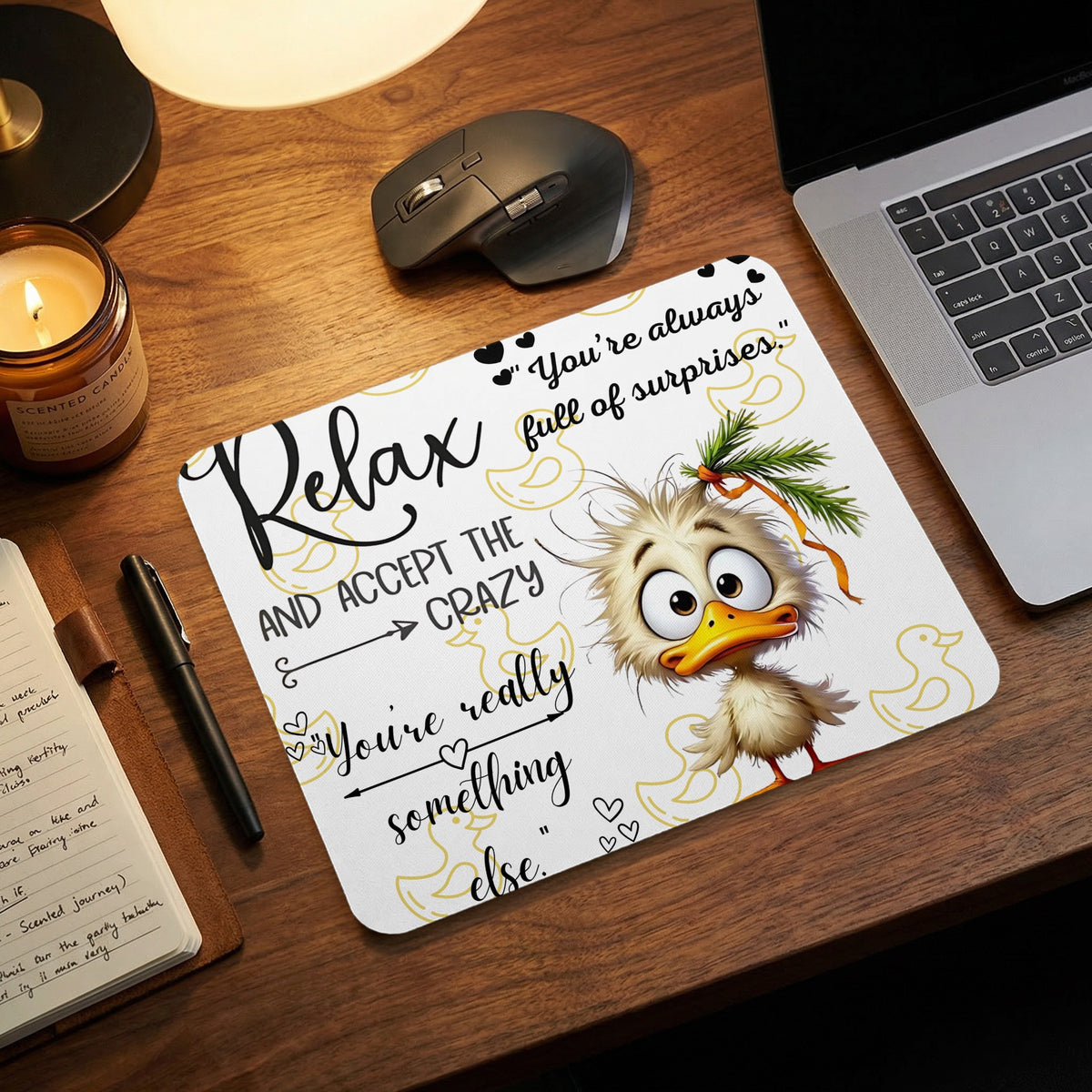 A mousepad featuring a cartoon duck and humorous text sits on a wooden desk.