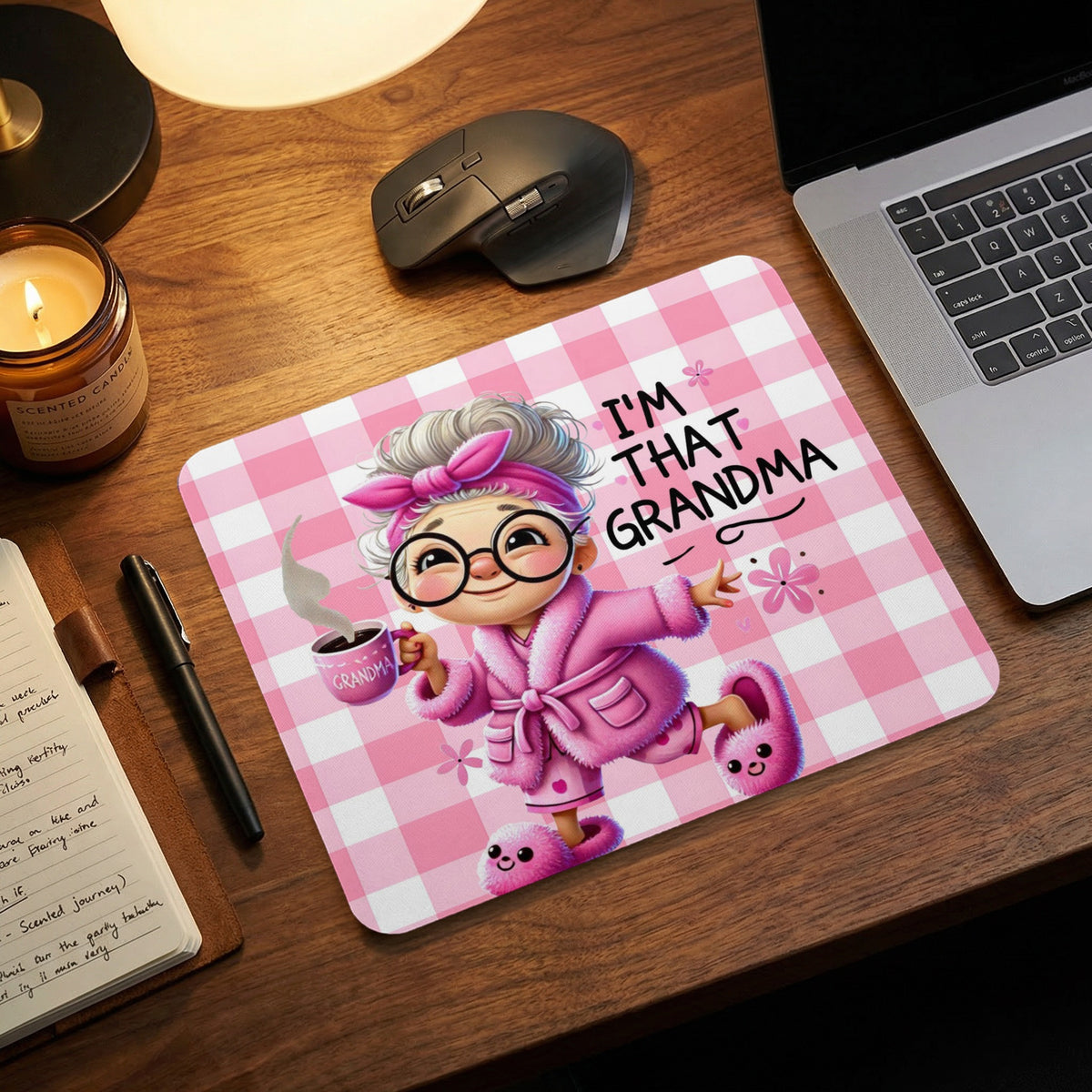 Pink gingham mousepad featuring an illustrated grandma in pajamas holding coffee and the text I'M THAT GRANDMA.