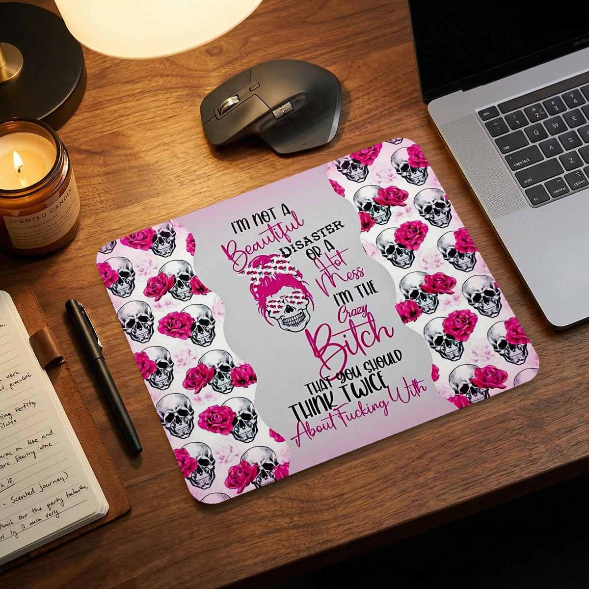 Rectangle mouse pad featuring a repeating skull and pink rose pattern with centered text on a wooden desk.