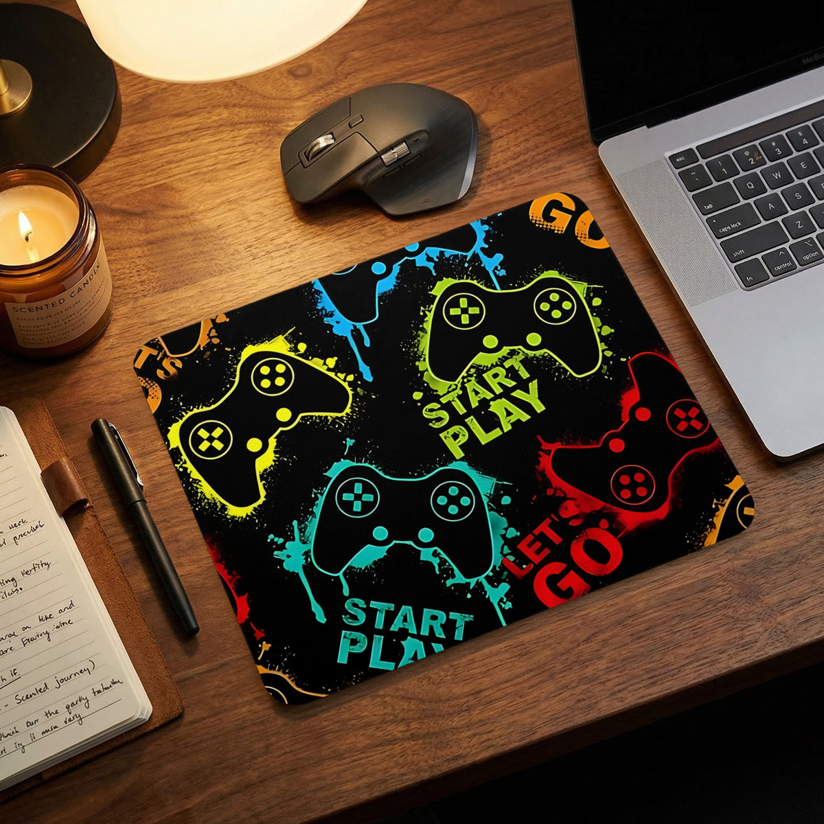 A black gaming mouse pad featuring colorful controller graphics and text on a wooden desk.