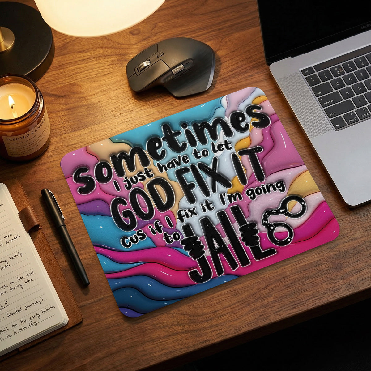 A colorful mousepad on a wooden desk with the text Sometimes I just have to let GOD FIX IT Cus if I fix it I'm going to JAIL.