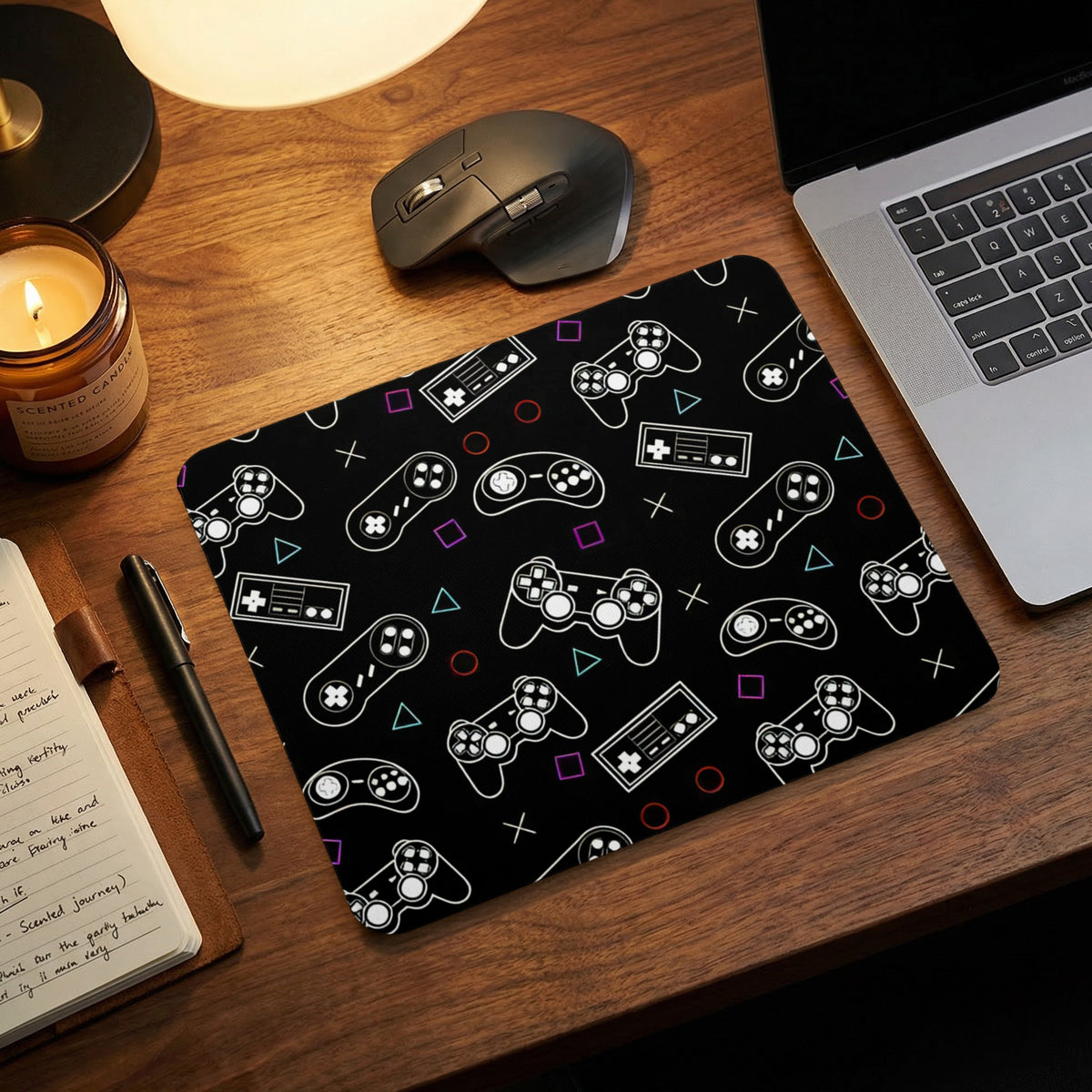 A black mousepad featuring a white video game controller pattern on a wooden desk.