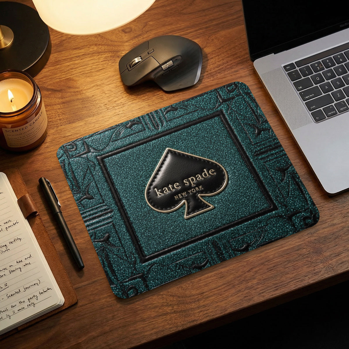 Kate Spade New York spade logo on a teal glitter textured mousepad.