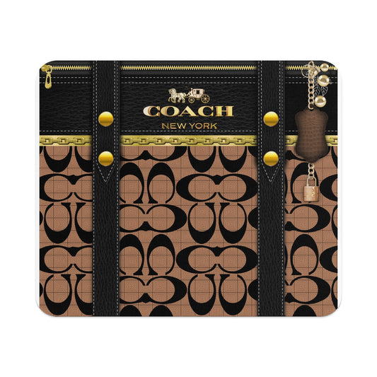 Coach patterned wallet with gold hardware and a hanging charm.
