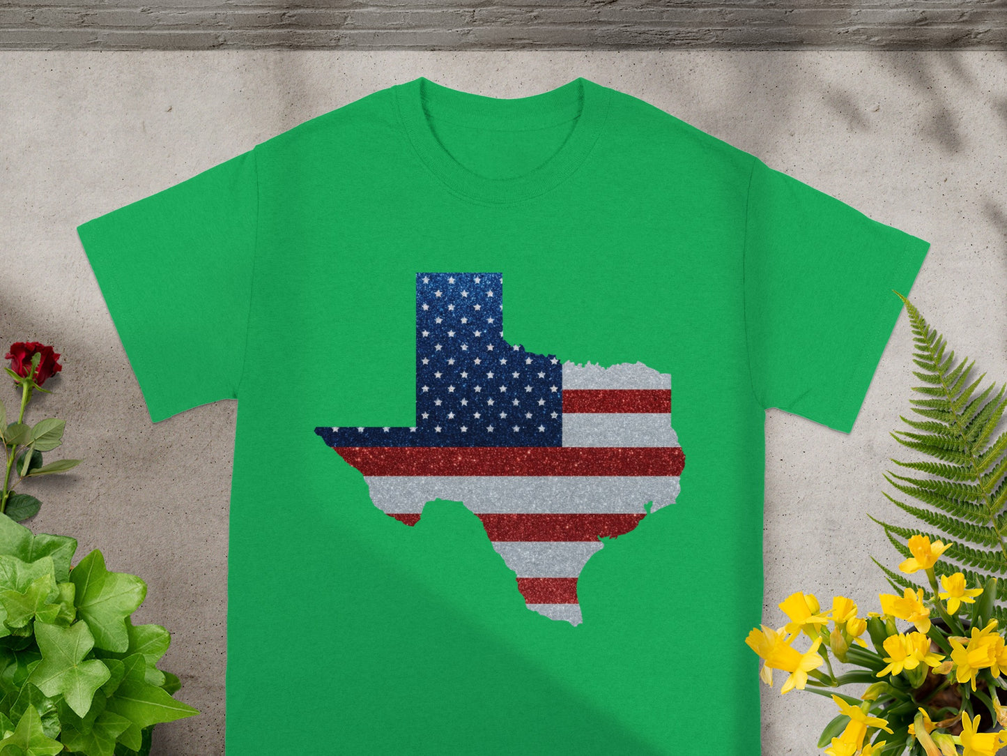Green t-shirt with a glittery Texas shape filled with the American flag pattern.
