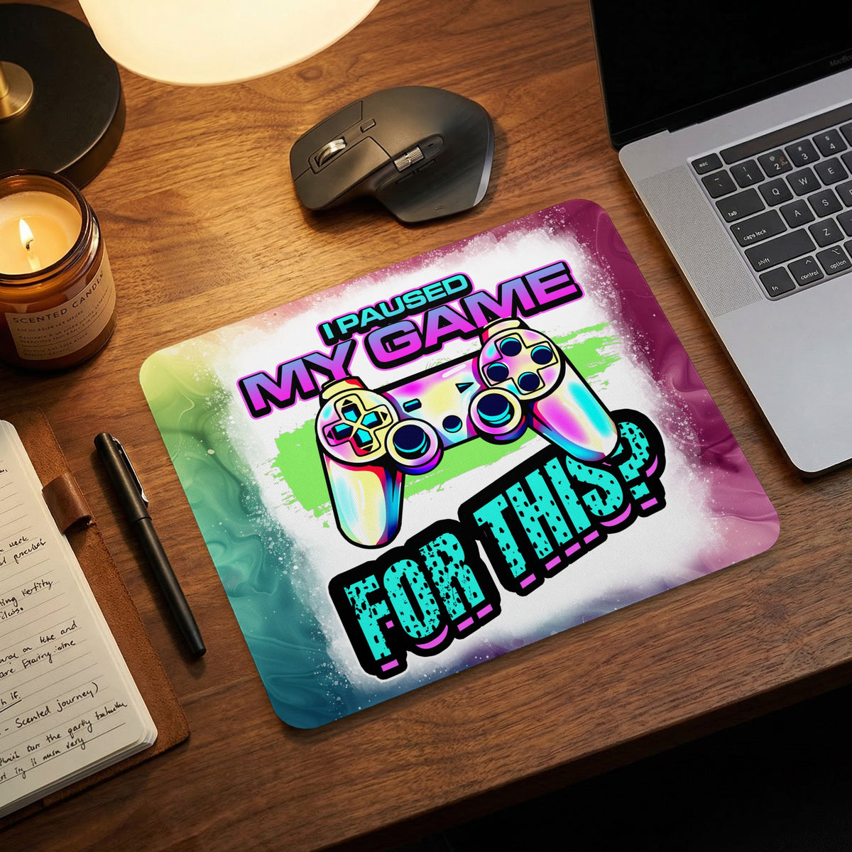 A colorful gaming mousepad with a retro controller illustration and the text I paused my game for this.