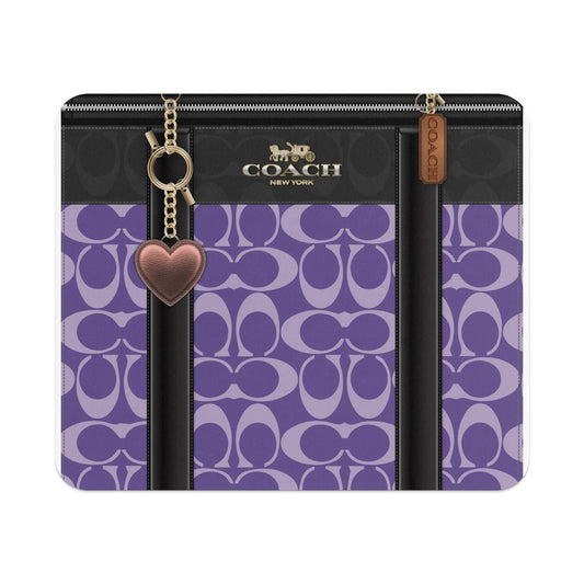 Coach bag with purple signature C pattern and heart keychain.
