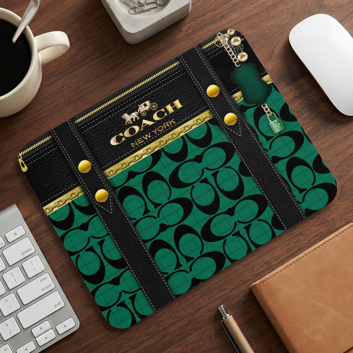 Coach mousepad with green signature pattern, black leather accents, and gold hardware.