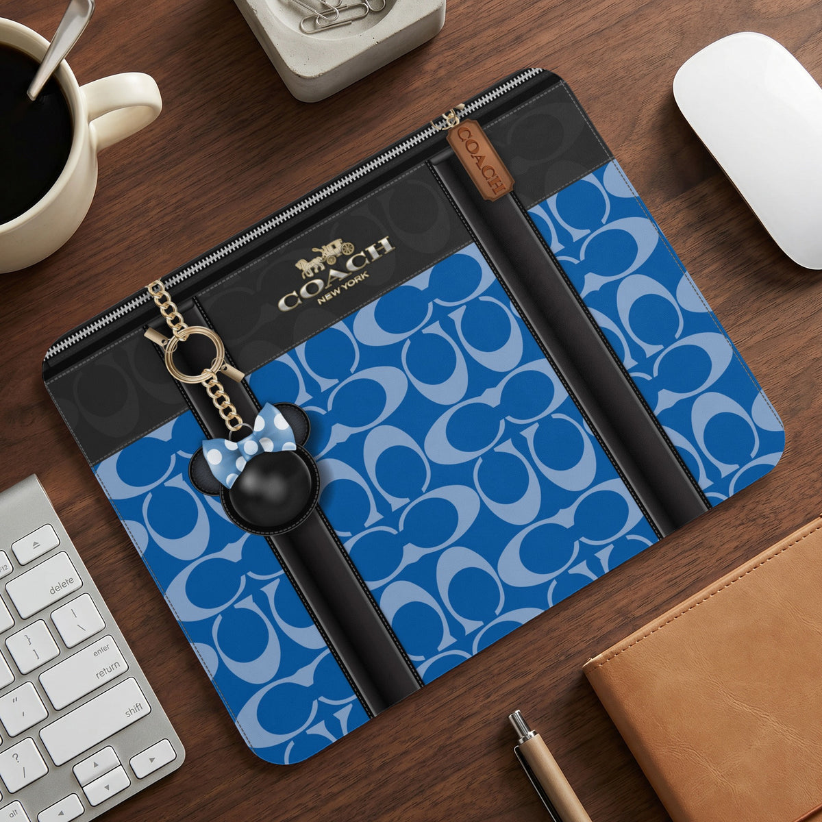 Coach laptop sleeve with blue C-pattern, black trim, and Minnie Mouse charm.