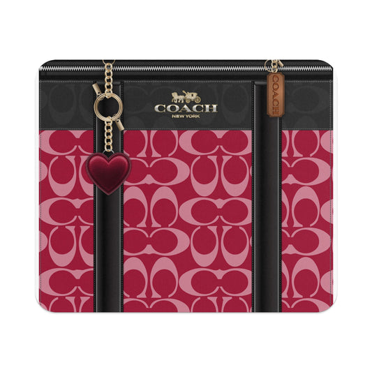 Coach canvas pattern with black trim and gold hardware, featuring a heart charm.