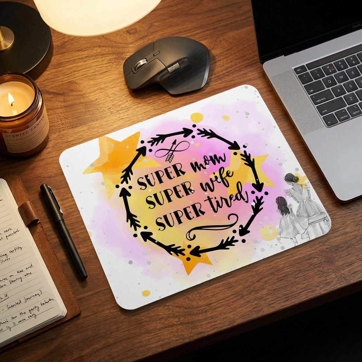 A rectangular mouse pad with a watercolor background features a circular arrow wreath and text reading "SUPER mom SUPER wife SUPER tired."