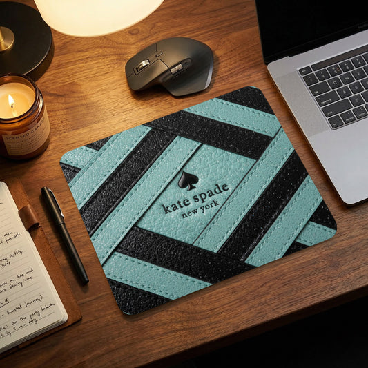 Kate Spade New York mousepad with black and teal stripes and spade logo.