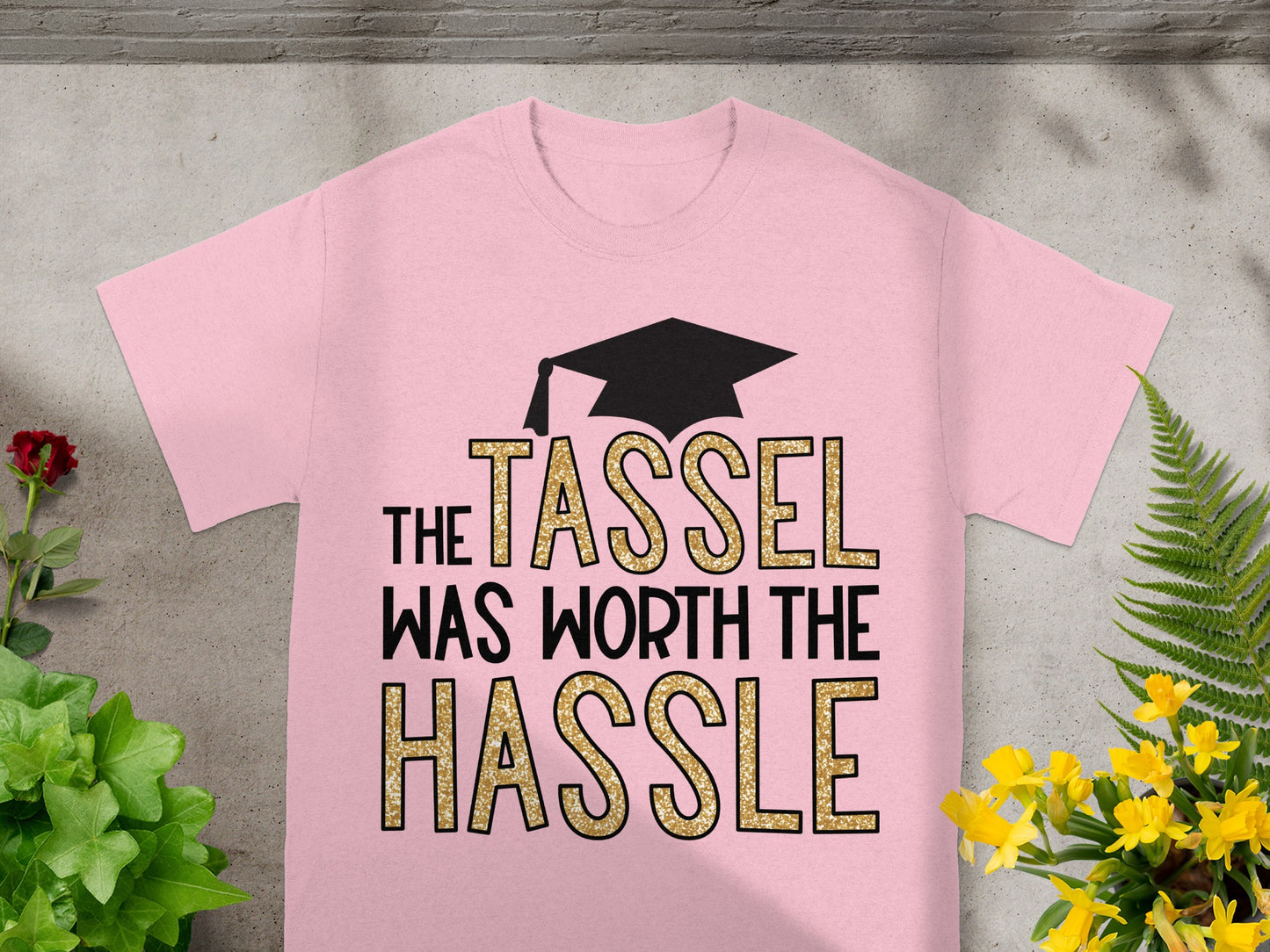 Pink t-shirt with "The Tassel Was Worth The Hassle" text and graduation cap.