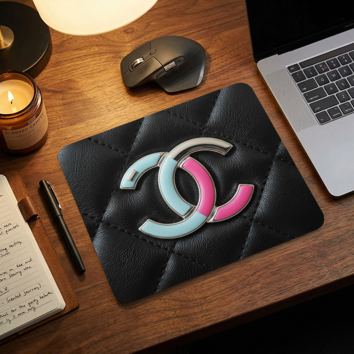 Quilted black mousepad with pastel pink and blue CC logo.