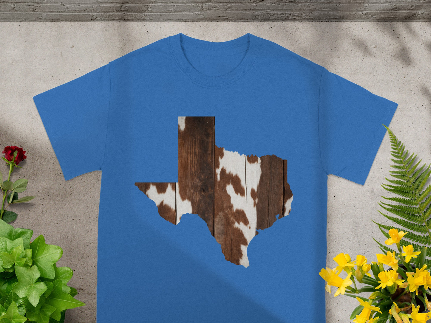Blue t-shirt with a Texas shaped cutout with wood and cowhide texture.