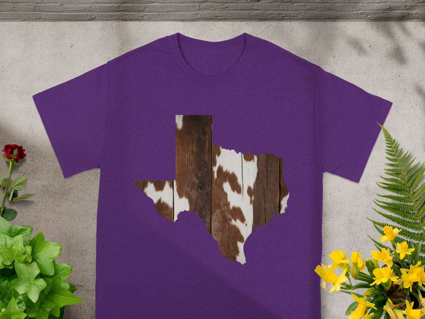 Purple t-shirt with a Texas outline filled with cowhide and wood texture.