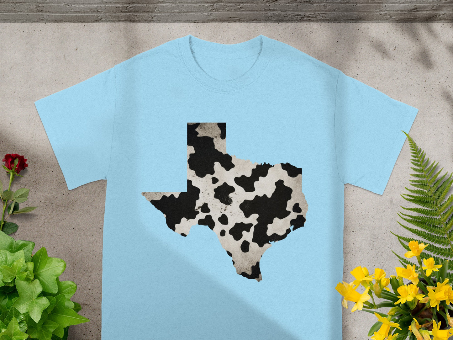 Light blue t-shirt featuring a Texas map silhouette with cowhide pattern.