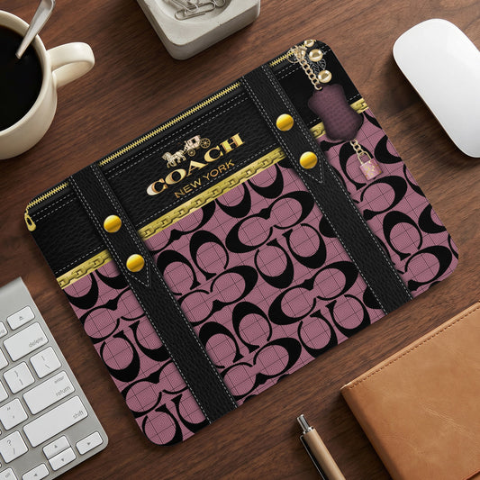 Coach New York mousepad with black, gold, and pink signature pattern.
