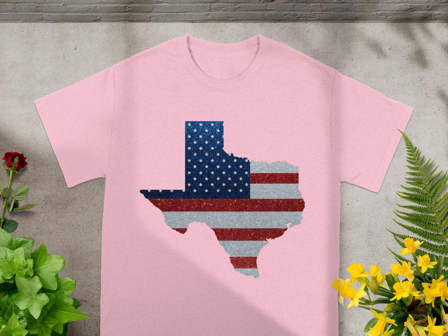 Pink t-shirt with Texas map outline filled with U.S. flag glitter design.