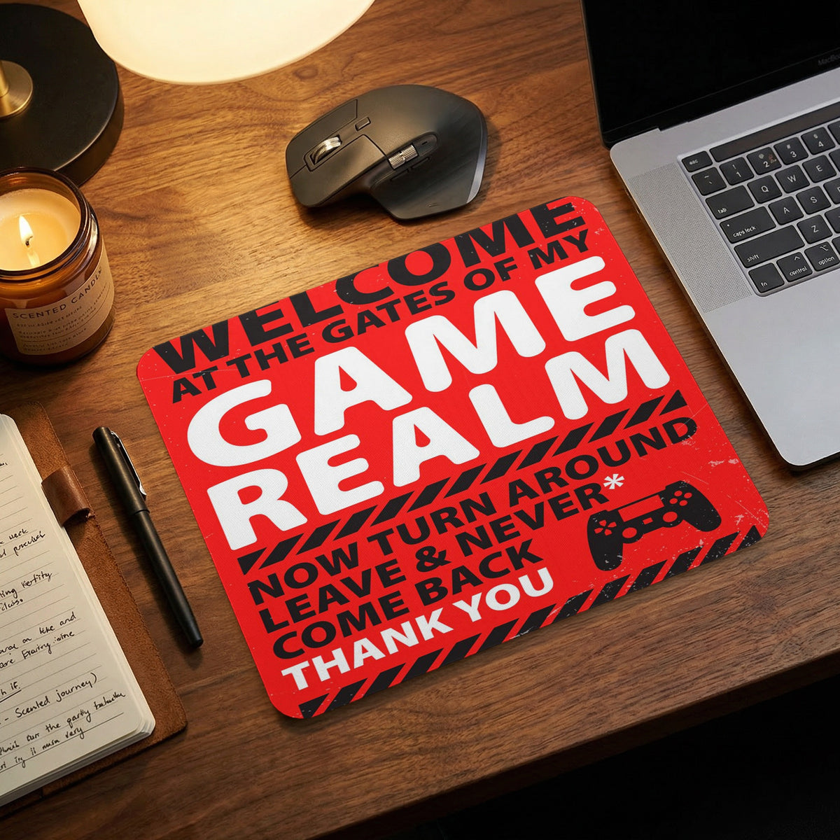 Red rectangular mousepad featuring bold text and a game controller graphic, placed on a wooden desk.