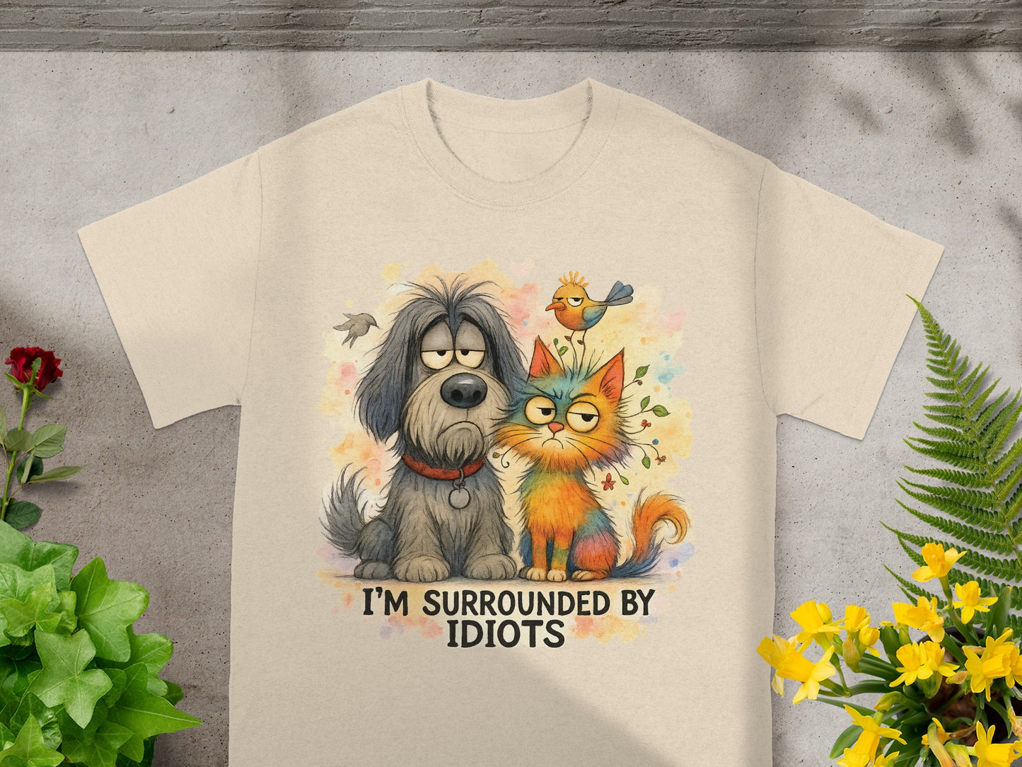 Beige t-shirt with distressed dog and cat graphic and "I'M SURROUNDED BY IDIOTS" text.