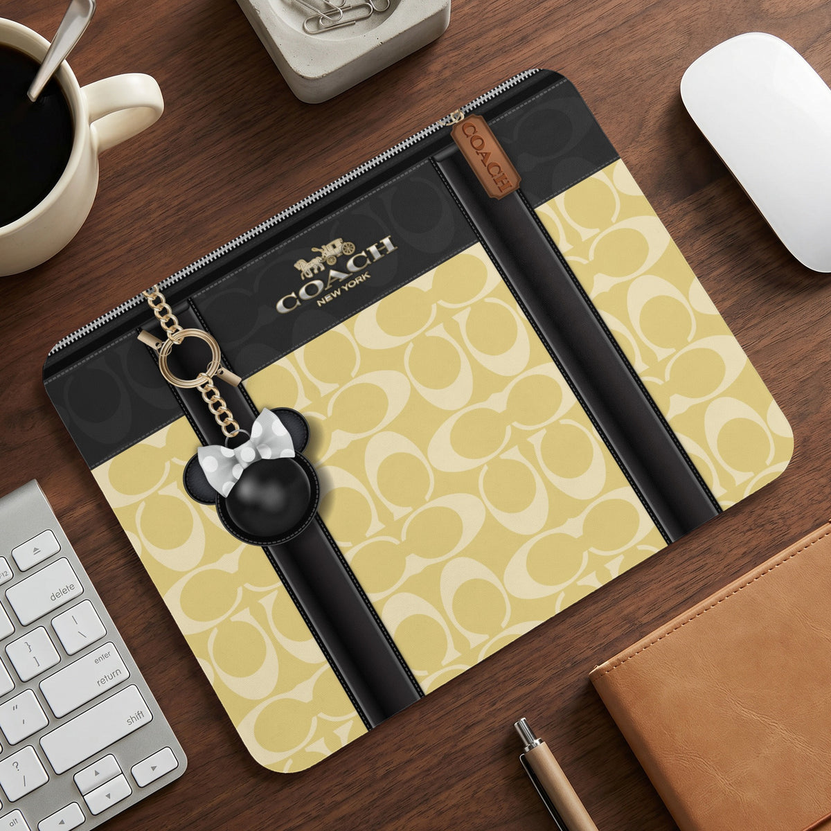Coach monogram print pouch with black trim and Mickey Mouse charm.