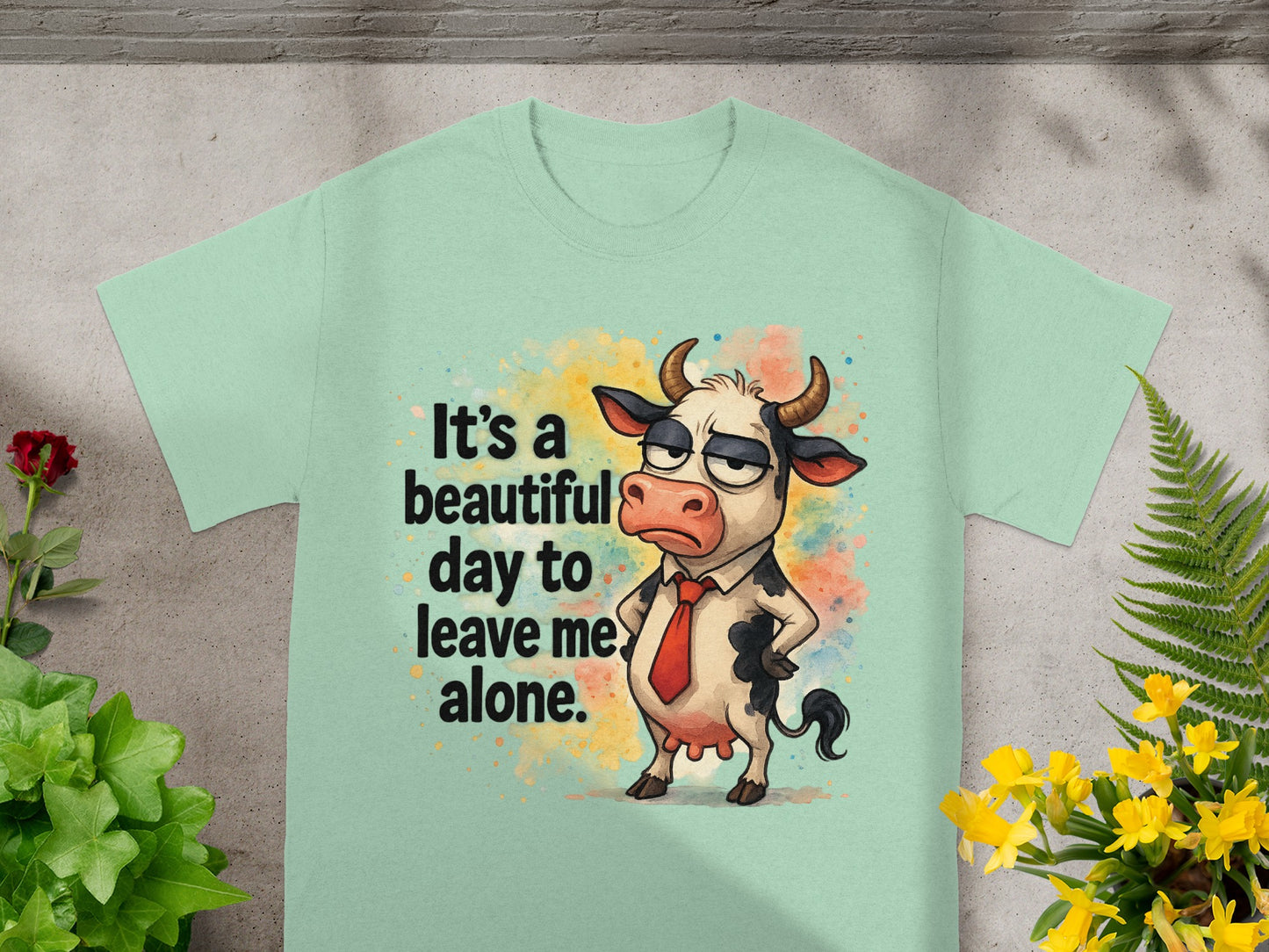 Light green t-shirt with cartoon cow wearing tie and text "It's a beautiful day to leave me alone."