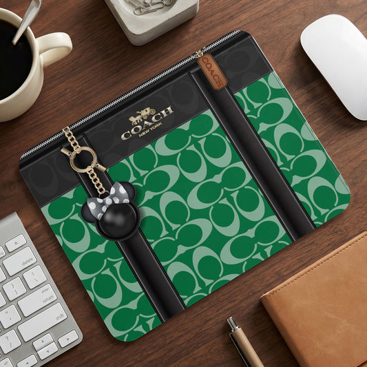 Coach green and black C-print tech accessory with Mickey Mouse charm.