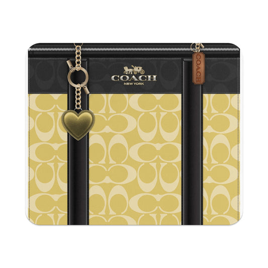 Coach New York wallet with gold heart charm and monogram pattern.