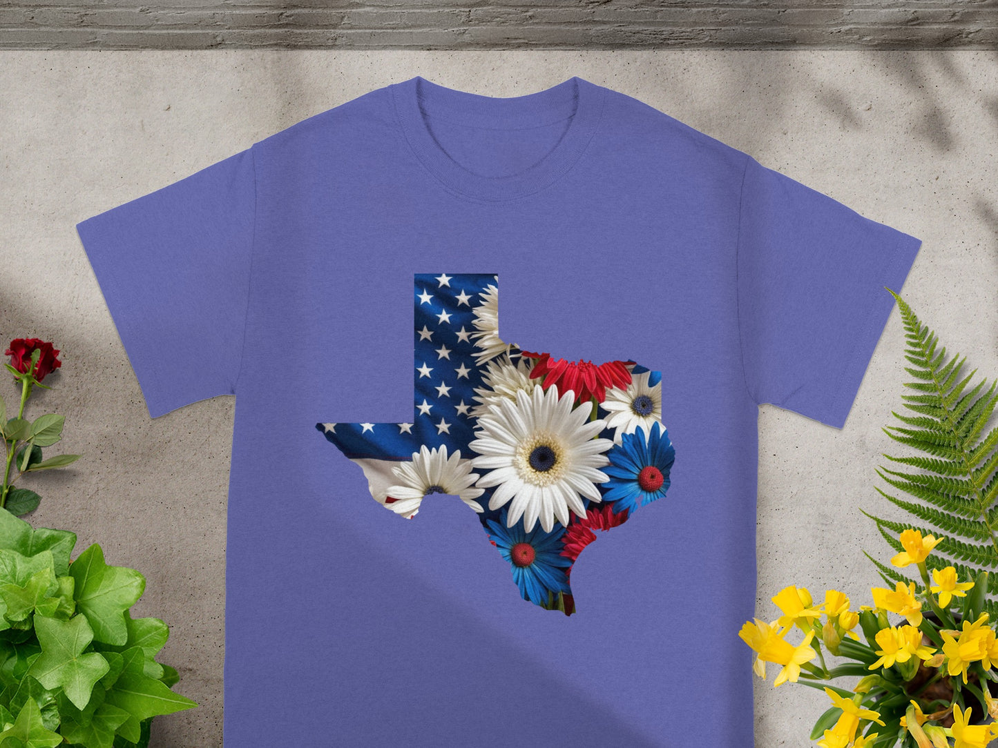 Purple t-shirt with Texas shape filled with American flag and white, red, and blue flowers.