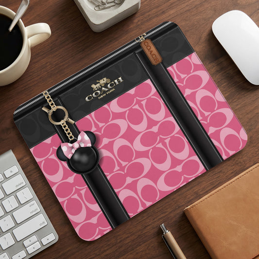 Coach zip-around case with pink signature print and Minnie Mouse charm.