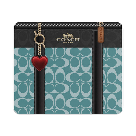 Coach wallet with Signature C pattern, gold hardware, and a red heart charm.