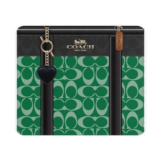 Coach green monogram wallet with black heart charm and gold chain details.