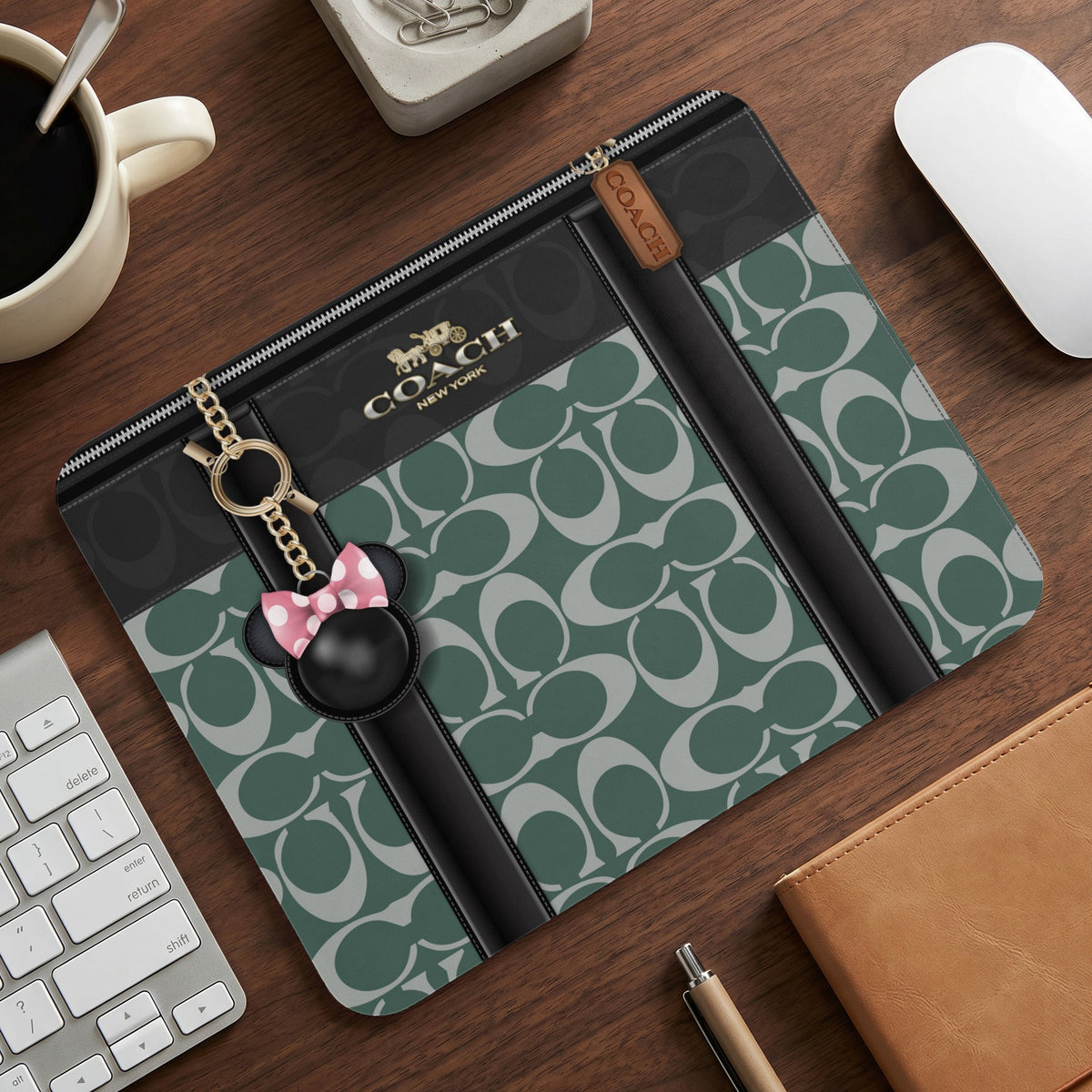 Coach document pouch with green C-monogram, gold hardware, and Minnie Mouse charm.