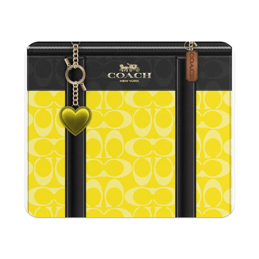 Coach monogram yellow and black wallet with gold heart charm and Coach tag.