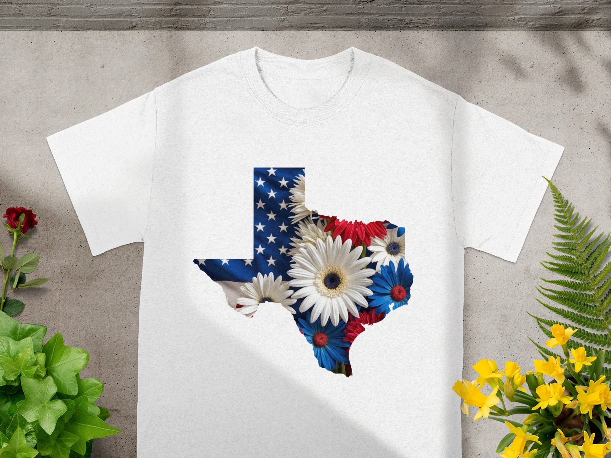 White t-shirt with Texas shape filled with US flag and red, white, and blue flowers.