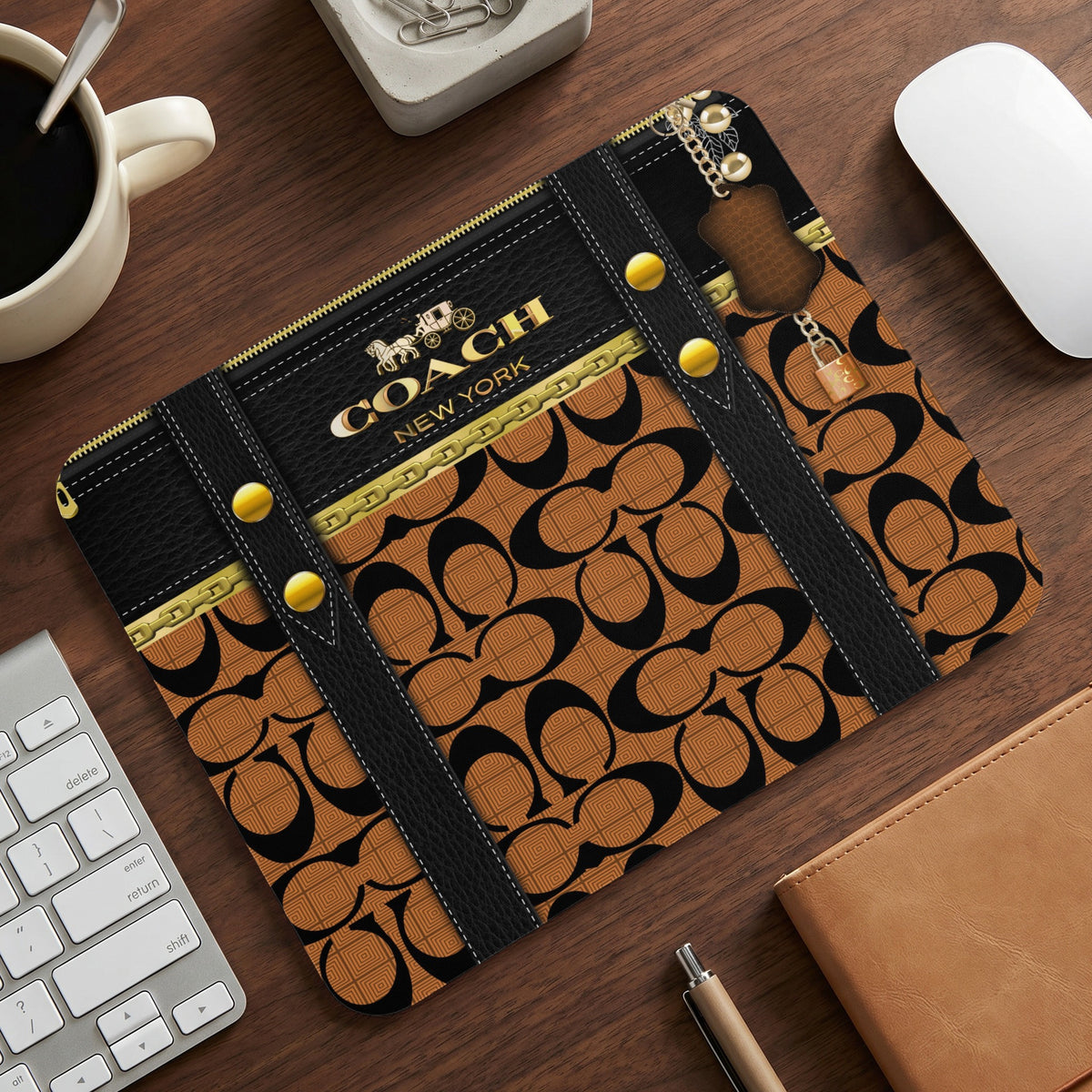 Coach New York mousepad with iconic logo pattern and gold hardware details.
